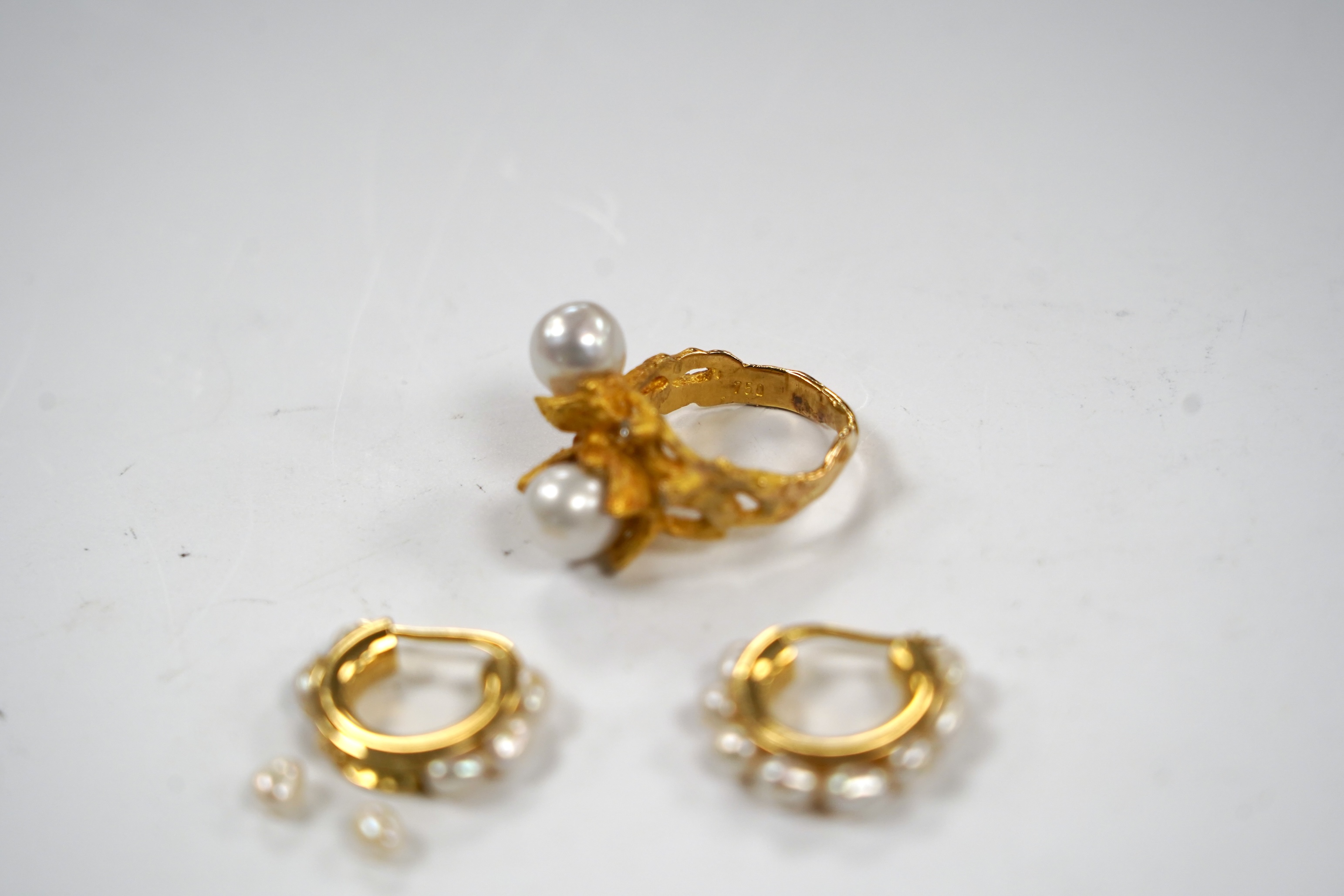 A recent 750 yellow metal two stone cultured pearl and three stone diamond chip set modernist ring, size M/N, gross 9.7 grams and a pair of baroque pearl set half hoop earrings (a.f.).